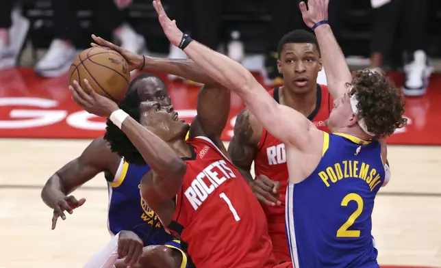 Golden State Warriors' Brandin Podziemski (2) defends Houston Rockets' Amen Thompson (1) during the first half of Game 1 of an NBA basketball first-round playoff series in Houston, Sunday, April 20, 2025. (Scott Strazzante/San Francisco Chronicle via AP)