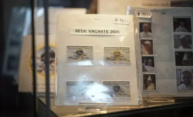 A series of 2025 Vatican Vacant Seat stamps are on display in the Filitalia stamps, coins, and souvenirs shop next to the Vatican walls, in Rome, Tuesday, April 29, 2025. (AP Photo/Andrew Medichini)