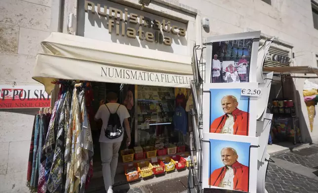 A person enters the Filitalia stamps, coins, and souvenirs shop just next to the Vatican walls in Rome, Tuesday, April 29, 2025. (AP Photo/Andrew Medichini)