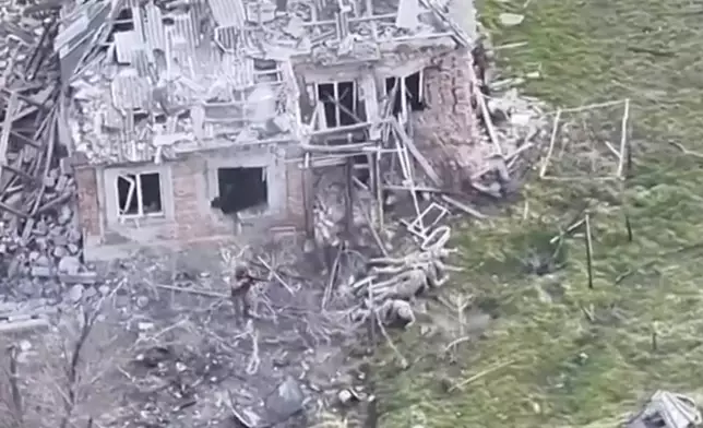 This image taken from video that European military officials say was filmed by a Ukrainian drone in the southern Ukrainian village of Piatykhatky on March 13, 2025, shows a soldier, left, identified as Russian, pointing his gun at four Ukrainian soldiers on the ground who appear to have surrendered. (Ukraine Military/European Defense Officials via AP)
