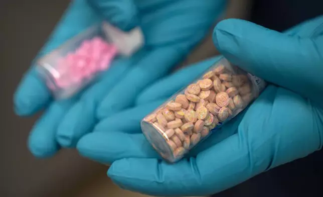 Jonathan Dumke, a senior forensic chemist with the Drug Enforcement Administration, holds vials of fentanyl pills at a DEA research laboratory on Tuesday, April 29, 2025, in Northern Virginia. (AP Photo/Mark Schiefelbein)