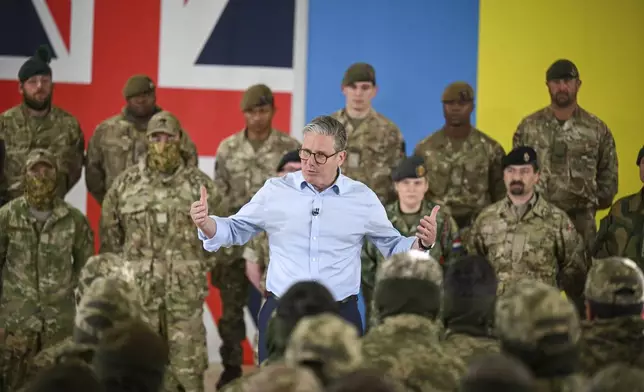 Britain's Prime Minister Keir Starmer, center, speaks to troops during a visit to a military base training Ukrainian troops with New Zealand's Prime Minister Christopher Luxon, in the west of England, Tuesday, April 22, 2025. (Finnbarr Webster/Pool Photo via AP)