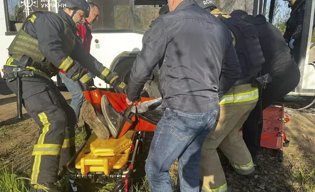 In this photo provided by the Ukrainian Emergency Service, rescuers carry out bodies of passengers after a Russian drone hit a public bus in Marhanets, Dnipropetrovsk region, Wednesday, April 23, 2025. (Ukrainian Emergency Service via AP)