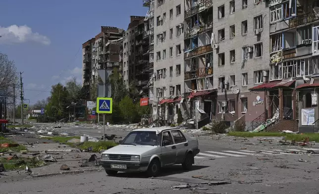An abandoned car stands against the background of damaged buildings in central Pokrovsk, the site of the heaviest battles with the Russian troops in the Donetsk region, Ukraine, Wednesday, April 23, 2025. (AP Photo/Michael Shtekel)