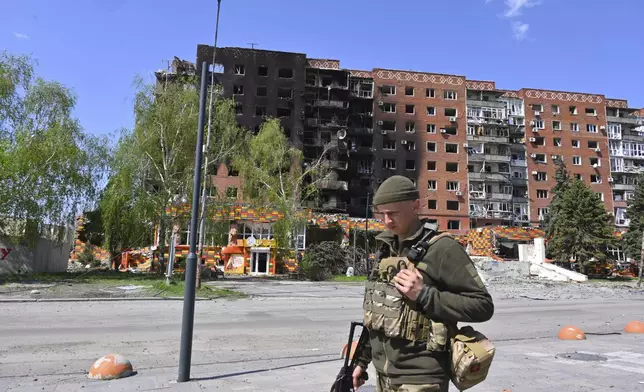 A Ukrainian soldier walks past damaged buildings in central Pokrovsk, the site of the heaviest battles with the Russian troops in the Donetsk region, Ukraine, Wednesday, April 23, 2025. (AP Photo/Michael Shtekel)