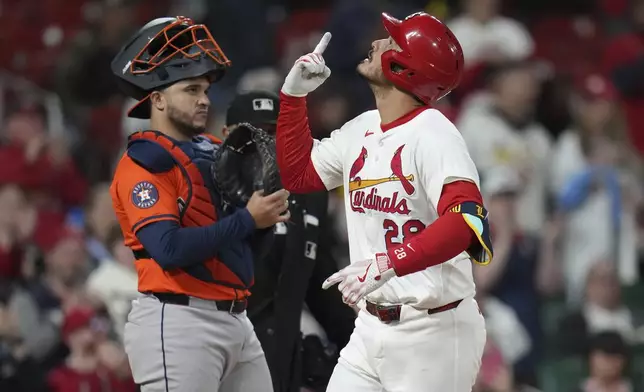St. Louis Cardinals' Nolan Arenado, right, celebrates as he arrives home after hitting a solo home run as Houston Astros catcher Yainer Diaz stands by during the seventh inning of a baseball game Monday, April 14, 2025, in St. Louis. (AP Photo/Jeff Roberson)