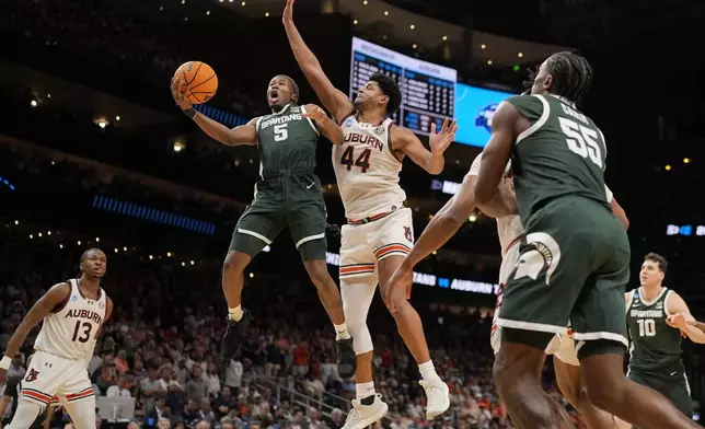 Michigan State guard Tre Holloman (5) shoots against Auburn center Dylan Cardwell (44) during the second half in the Elite Eight of the NCAA college basketball tournament, Sunday, March 30, 2025, in Atlanta. (AP Photo/George Walker IV)