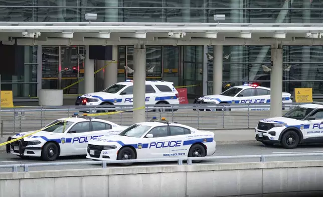 Police cars are pictured at the scene of police-involved shooting at the departures area of terminal 1 at Toronto Pearson International Airport, in Mississauga, Ontario, Canada, Thursday, April 24, 2025. (Arlyn McAdorey/The Canadian Press via AP)