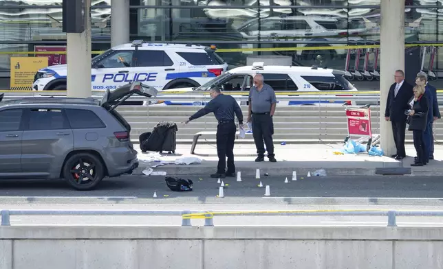 Officials view the scene of police-involved shooting at the departures area of terminal 1 at Toronto Pearson International Airport, in Mississauga, Ontario, Canada, Thursday, April 24, 2025. (Arlyn McAdorey/The Canadian Press via AP)