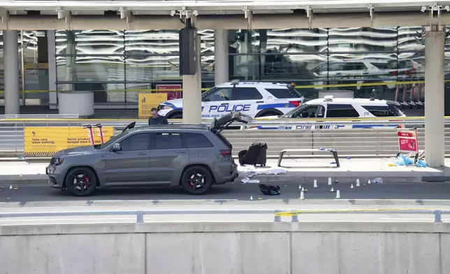 Evidence markers are placed at the scene of a police-involved shooting at the departures area of terminal 1 at Toronto Pearson International Airport, in Mississauga, Ontario, Canada, Thursday, April 24, 2025. (Arlyn McAdorey/The Canadian Press via AP)