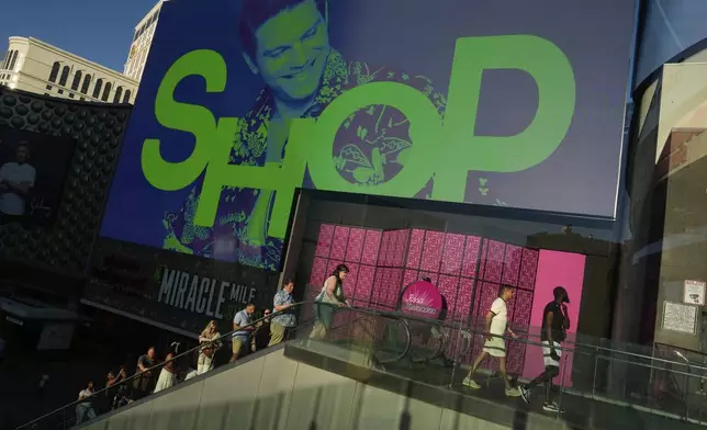 People walk by a shopping mall along the Las Vegas Strip, Tuesday, April 8, 2025, in Las Vegas. (AP Photo/John Locher)