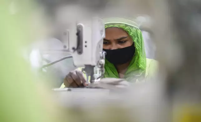 A worker stitches a garment at a factory run by the Bangladesh based Urmi Group in Narayanganj, Bangladesh, Tuesday, April 8, 2025. (AP Photo/Mahmud Hossain Opu)