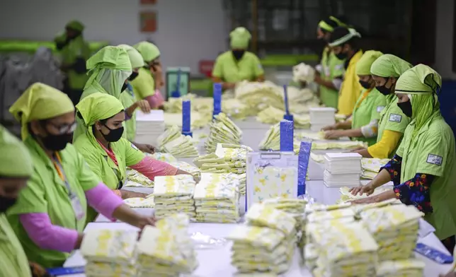 Workers pack garments produced at a factory run by the Bangladesh based Urmi Group in Narayanganj, Bangladesh, Tuesday, April 8, 2025. (AP Photo/Mahmud Hossain Opu)