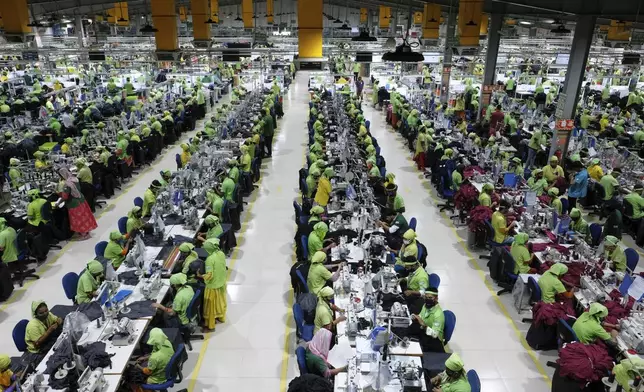 Factory workers operate machines to make garments at UHM Ltd. in Narayaganj, Bangladesh, Tuesday, April 8, 2025. (AP Photo/Mahmud Hossain Opu)