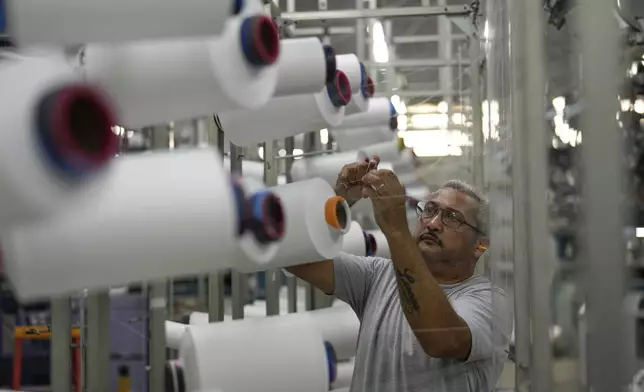 A man works on the production line at a textile manufacturer in Sao Paulo, Wednesday, April 9, 2025. (AP Photo/Andre Penner)
