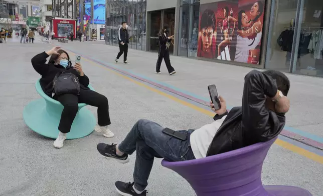 Visitors rest on wobbling seats in Beijing, China, Tuesday, April 8, 2025. (AP Photo/Ng Han Guan)