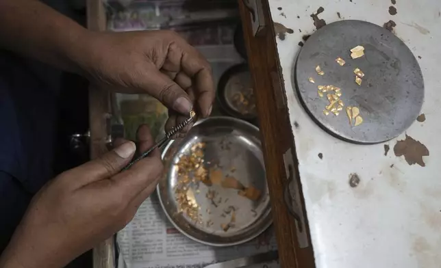 A goldsmith makes gold jewelry in Ahmedabad, India, Tuesday, April 8, 2025. (AP Photo/Ajit Solanki)