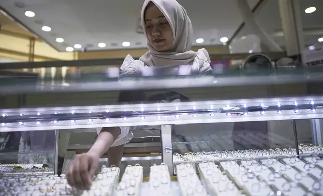 A vendor arranges gold jewelry in Jakarta, Indonesia, Thursday, April 10, 2025. (AP Photo/Achmad Ibrahim)