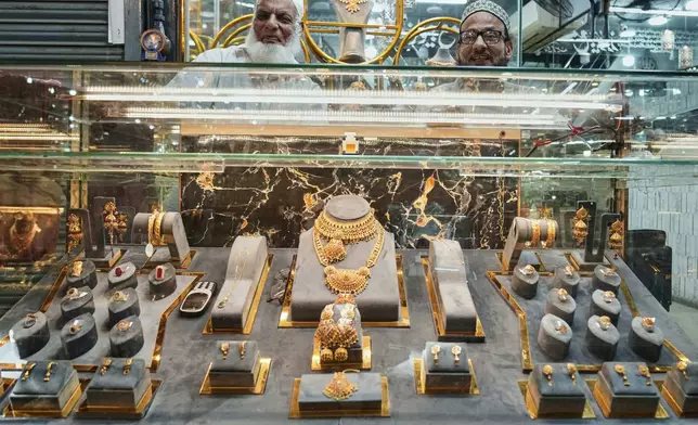Goldsmith wait for customers at their gold jewelry shop in Lahore, Pakistan, Tuesday, April 8, 2025. (AP Photo/K.M. Chaudary)