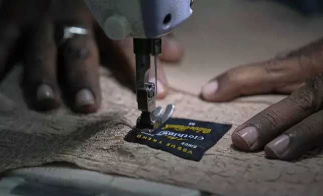 A tailor stitches a men shirt at a small factory in Karachi, Pakistan, Tuesday, April 8, 2025. (AP Photo/Fareed Khan)