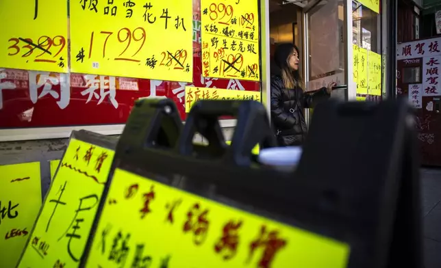 A woman exits a local market in New York's Chinatown, Tuesday, April 8, 2025. (AP Photo/Eduardo Munoz Alvarez)