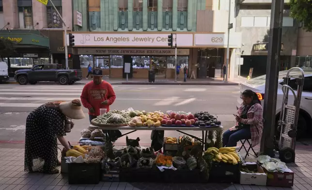 A vendor sells fruits in downtown Los Angeles, Tuesday, April 8, 2025. (AP Photo/Jae C. Hong)