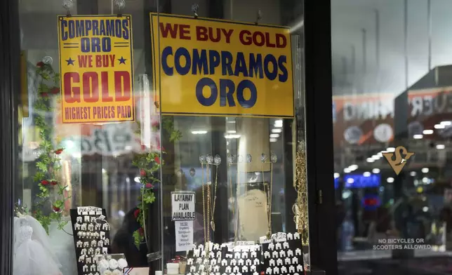 "We Buy Gold" signs are displayed in the window of a jewelry store in Los Angeles, Tuesday, April 8, 2025. (AP Photo/Jae C. Hong)