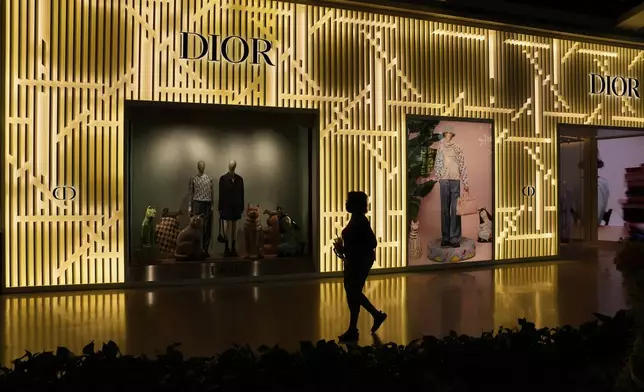 A person walks by a Dior store Tuesday, April 8, 2025, in Las Vegas. (AP Photo/John Locher)