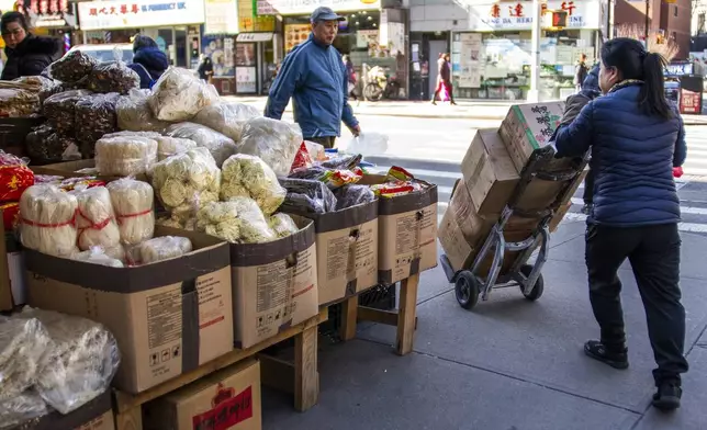 A woman pushes her cart with dried noodles at Chinatown in New York, Tuesday, April 8, 2025. (AP Photo/Eduardo Munoz Alvarez)