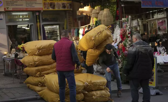 A man unloads sacks with goods in a gifts whole-store at Eminonu commercial area, in Istanbul, Turkey, Wednesday, April 9, 2025. (AP Photo/Francisco Seco)