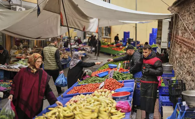 A seller attends a client at the Fener street food market, in Istanbul, Turkey, Tuesday, April 8, 2025. (AP Photo/Francisco Seco)