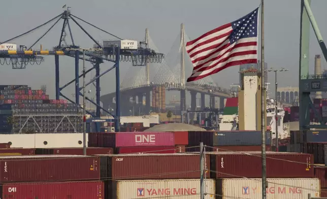 Containers with Yang Ming Marine Transport Corporation, a Taiwanese container shipping company, are stacked up at the Port of Los Angeles with the the Long Beach International Gateway Bridge seen in the background on Wednesday, April 9, 2025 in Los Angeles. (AP Photo/Damian Dovarganes)