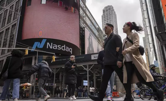 People walk past the Nasdaq MarketSite, Thursday, April 10, 2025, in New York. (AP Photo/Yuki Iwamura)