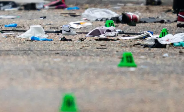 Shoes and evidence markers lay on the street while police investigate after a vehicle drove into a crowd Saturday killing multiple people at a street festival, in Vancouver, British Columbia, Sunday, April 27, 2025. (Rich Lam/The Canadian Press via AP)