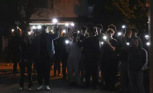 Attendees hold cell phone lights during a vigil for victims after a vehicle drove into a crowd during a Filipino heritage festival in Vancouver, British Columbia, Sunday, April 27, 2025. (AP Photo/Lindsey Wasson)