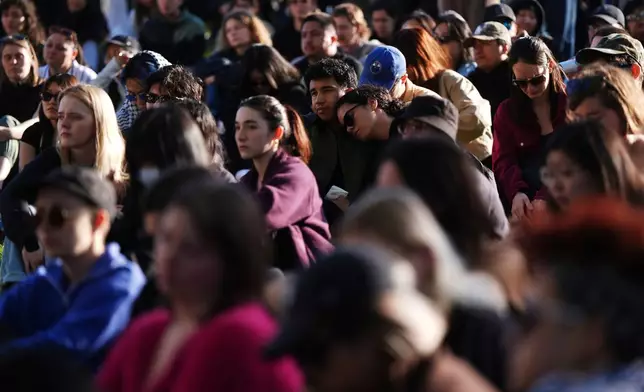 People listen as community leaders speak during a vigil for the victims after a vehicle drove into a crowd Saturday and killed multiple people at a Filipino heritage festival, in Vancouver, British Columbia, Sunday, April 27, 2025. (Darryl Dyck/The Canadian Press via AP)