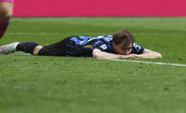 Inter Milan's Nicolo Barella lies on the pitch after missing a chance to score during the Serie A soccer match between Inter Milan and Roma at the San Siro Stadium, in Milan, Italy, Sunday, April 27, 2025. (AP Photo/Antonio Calanni)