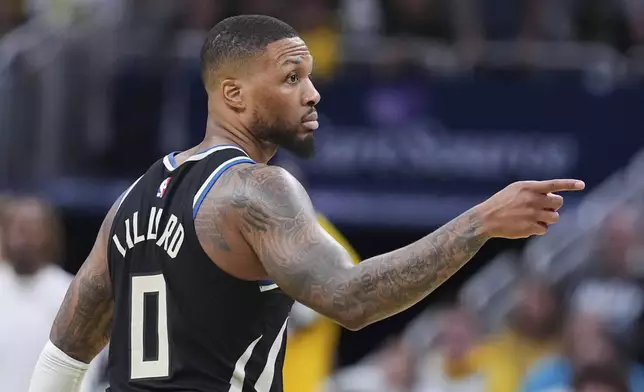 Milwaukee Bucks guard Damian Lillard (0) gestures after a three-point basket against the Indiana Pacers during the second half of a first-round NBA basketball playoff game in Indianapolis, Tuesday, April 22, 2025. (AP Photo/Michael Conroy)