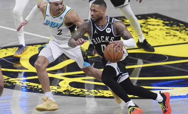 Milwaukee Bucks guard Damian Lillard (0) drives on Indiana Pacers guard Andrew Nembhard (2) during the first half of a first-round NBA basketball playoff game in Indianapolis, Tuesday, April 22, 2025. (AP Photo/Michael Conroy)