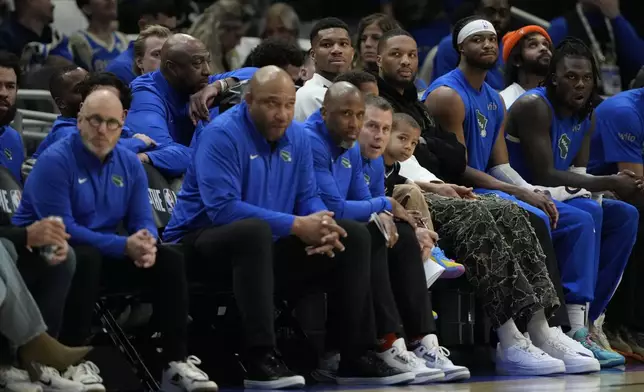 Milwaukee Bucks' Giannis Antetokounmpo and Damian Lillard watch from the bench during the first half of an NBA basketball game against the Detroit Pistons, Sunday, April 13, 2025, in Milwaukee. (AP Photo/Aaron Gash)