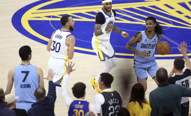 Golden State Warriors' Gary Payton II, top, and Stephen Curry (30) and Memphis Grizzlies' Ja Morant (12) react after Grizzlies turned the ball over on an out-of-bounds play in final seconds of the second half of an NBA play-in tournament basketball game in San Francisco, Tuesday, April 15, 2025. (Scott Strazzante/San Francisco Chronicle via AP)