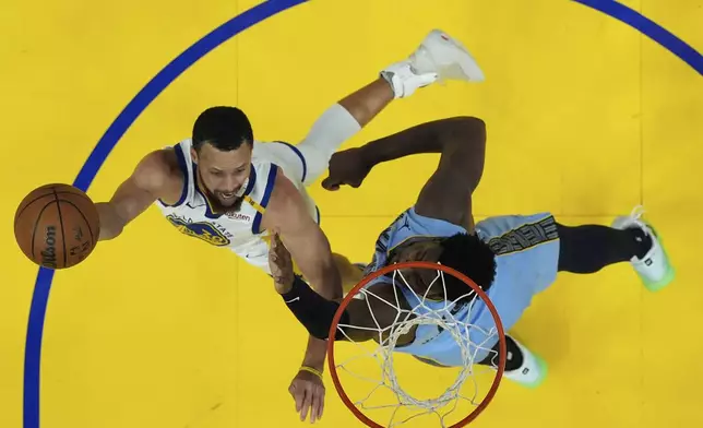 Golden State Warriors guard Stephen Curry, left, shoots against Memphis Grizzlies forward Jaren Jackson Jr. during the second half of an NBA play-in tournament basketball game in San Francisco, Tuesday, April 15, 2025. (AP Photo/Jeff Chiu)