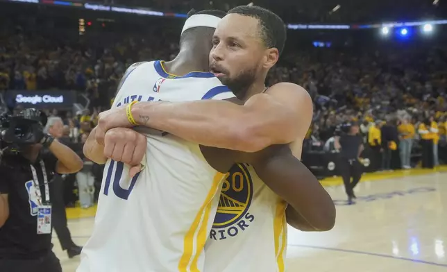 Golden State Warriors forward Jimmy Butler III, left, celebrates with guard Stephen Curry after an NBA play-in tournament basketball game against the Memphis Grizzlies in San Francisco, Tuesday, April 15, 2025. (AP Photo/Jeff Chiu)
