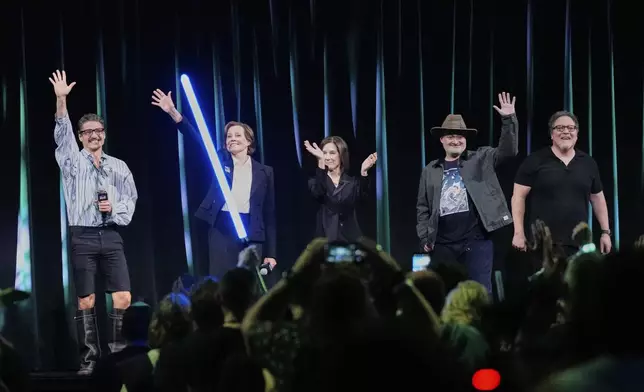From left, actors Pedro Pascal, Sigourney Weaver, film producer Kathleen Kennedy, directors Dave Filoni and Jon Favreau wave at audience members at the end of a program during a fan convention called the Star Wars Celebration Japan in Chiba, near Tokyo, Friday, April 18, 2025. (AP Photo/Hiro Komae)