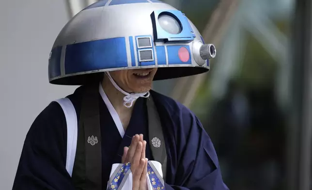 A Star Wars fan in an R2-D2 costume poses for a photo outside the venue during a fan convention called the Star Wars Celebration in Chiba, near Tokyo, Friday, April 18, 2025. (AP Photo/Hiro Komae)