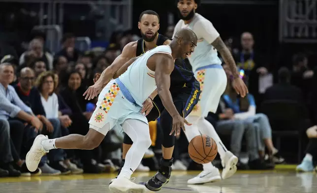 San Antonio Spurs guard Chris Paul, left, moves the ball while defended by Golden State Warriors guard Stephen Curry during the first half of an NBA basketball game Wednesday, April 9, 2025, in San Francisco. (AP Photo/Godofredo A. Vásquez)