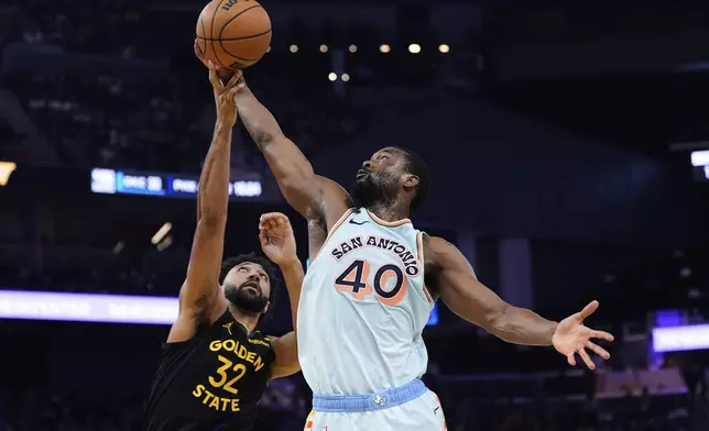 San Antonio Spurs forward Harrison Barnes (40) and Golden State Warriors center Trayce Jackson-Davis (32) compete for a rebound during the first half of an NBA basketball game Wednesday, April 9, 2025, in San Francisco. (AP Photo/Godofredo A. Vásquez)