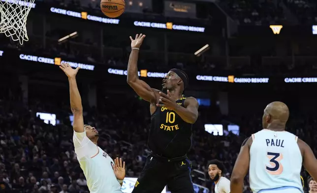 Golden State Warriors forward Jimmy Butler III (10) shoots next to San Antonio Spurs forward Keldon Johnson, left, during the first half of an NBA basketball game Wednesday, April 9, 2025, in San Francisco. (AP Photo/Godofredo A. Vásquez)