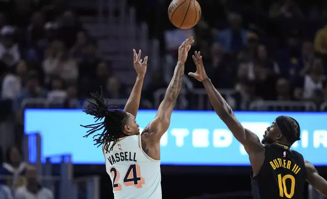 San Antonio Spurs guard Devin Vassell (24) shoots a 3-point basket over Golden State Warriors forward Jimmy Butler III (10) during the first half of an NBA basketball game Wednesday, April 9, 2025, in San Francisco. (AP Photo/Godofredo A. Vásquez)