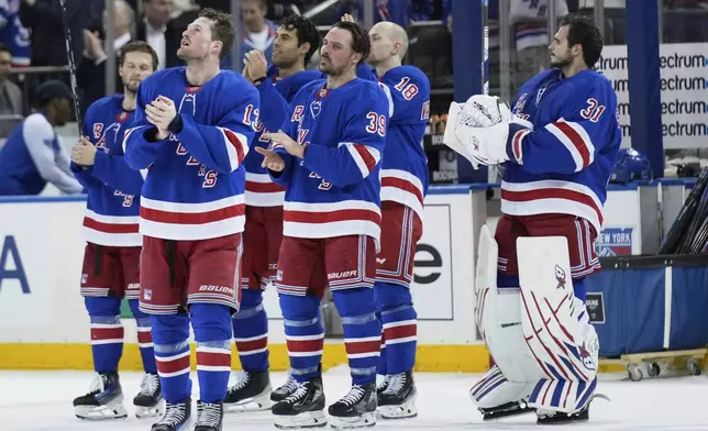 The New York Rangers look up to the broadcast booth as they honor Sam Rosen after an NHL hockey game against the Tampa Bay Lightning in New York, Thursday, April 17, 2025. Rosen is retiring after 40 seasons working with the Rangers. (AP Photo/Seth Wenig)